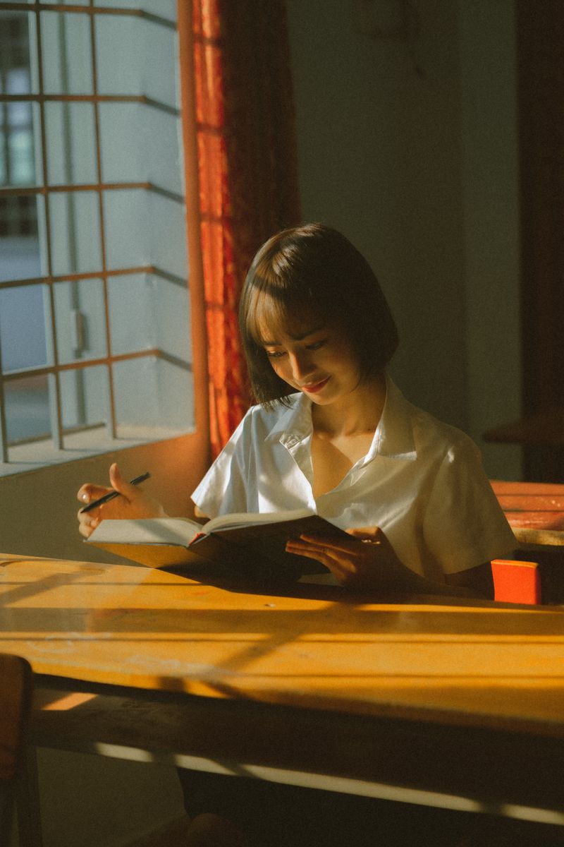 Student reading at a sunlit desk, deeply engaged in learning