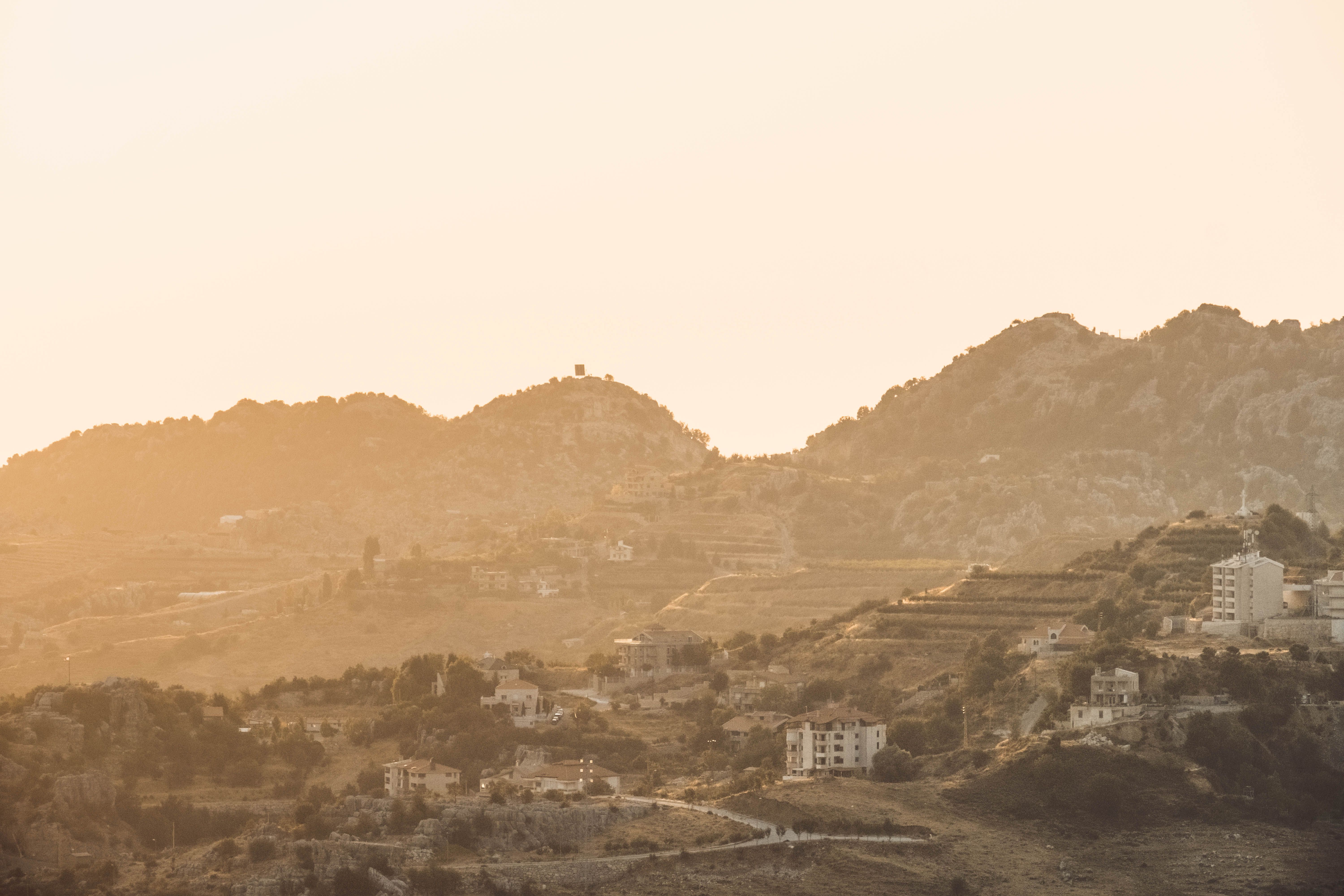 Capture of a serene mountain village landscape bathed in warm sunrise light.