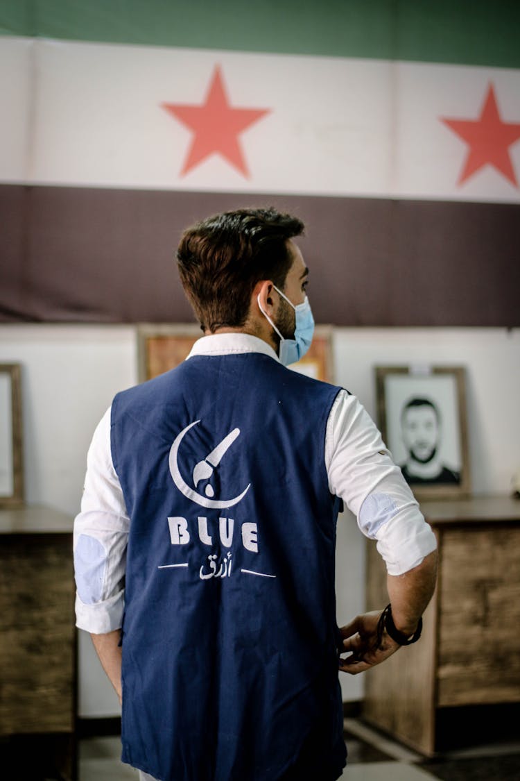 Back View Of A Man Wearing A Blue Vest