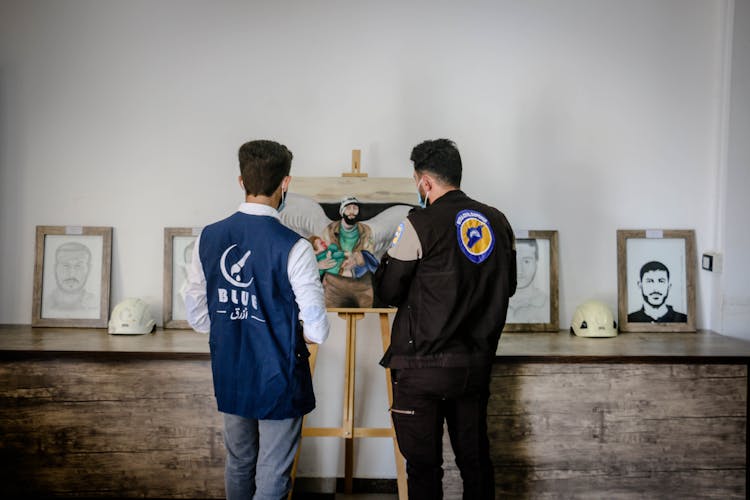 Framed Pictures Of Men On The Wooden Counter Top