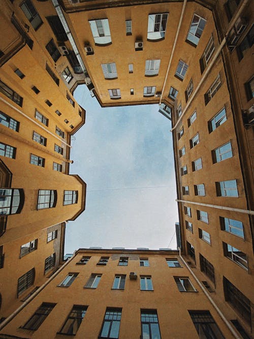 Low Angle Shot of Brown Concrete Buildings Under the Blue Sky 