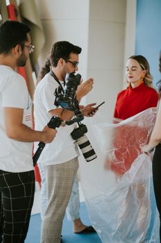 Behind-the-scenes look at a fashion photoshoot with models and photographers.
