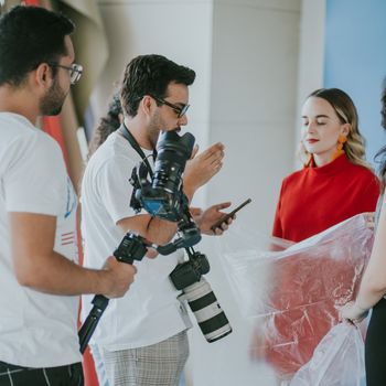 Behind-the-scenes look at a professional photoshoot setup with models and photographers.