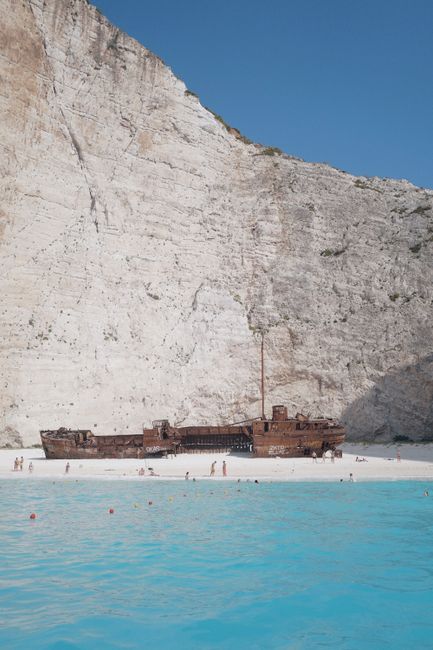 Stunning view of the famous shipwreck on Navagio Beach, Zakynthos, Greece, with clear blue waters and towering cliffs.