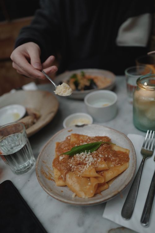 Free A cozy restaurant setting with a plate of pasta being served, emphasizing culinary delights. Stock Photo