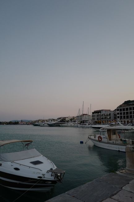 A serene scene of boats docked at a harbor under a dim, gray sky, reflecting tranquility and calm.