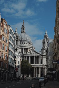 St. Paul's Cathedral stands majestically among London city buildings under a clear sky.
