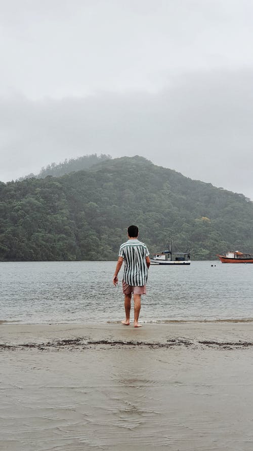 Back View of a Man Walking on Shore