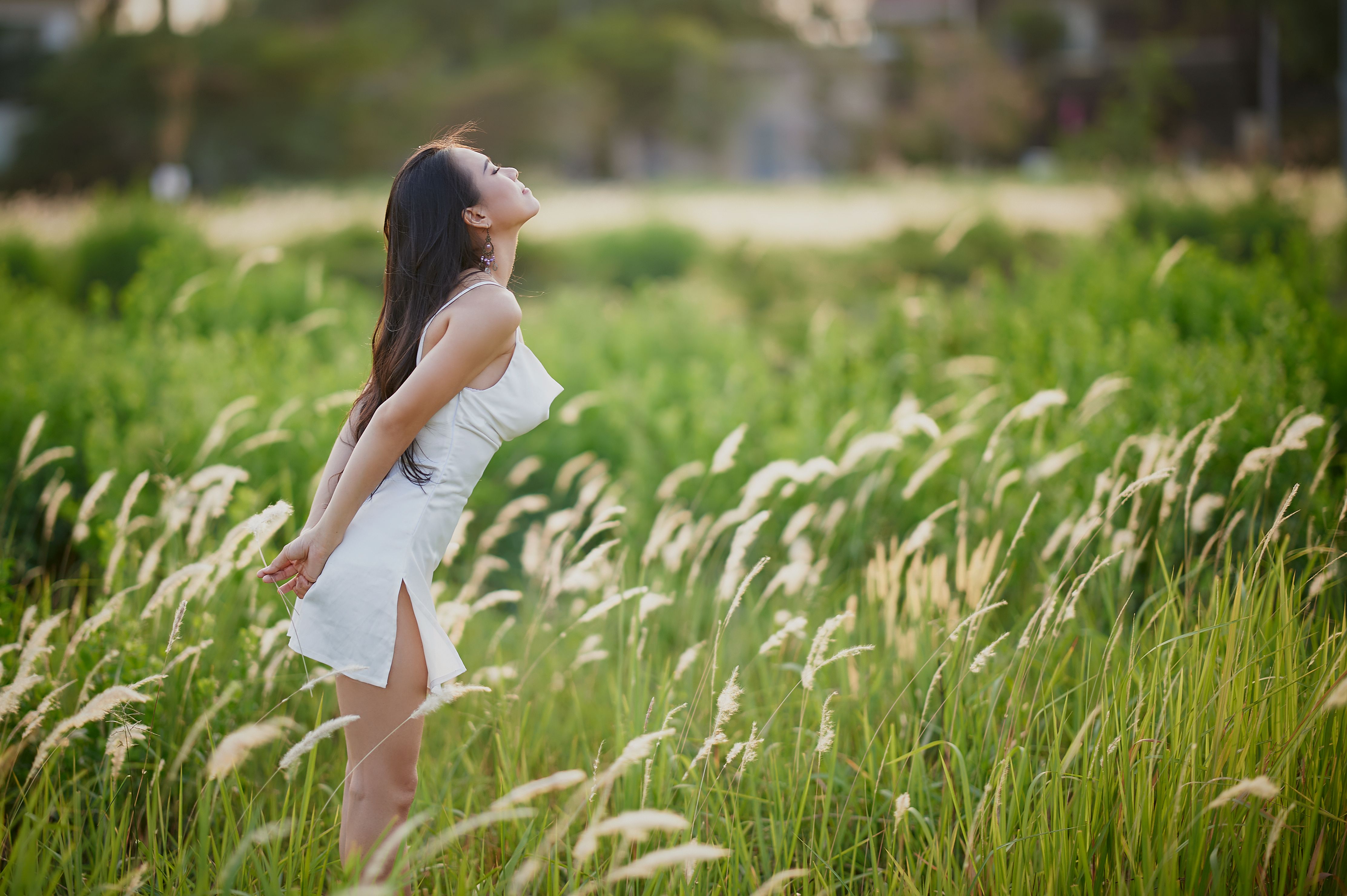 A Woman in White Dress Standing on the Field with Her Eyes Closed ...