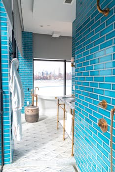 Elegant bathroom with teal tiles and a view of the New York City skyline.