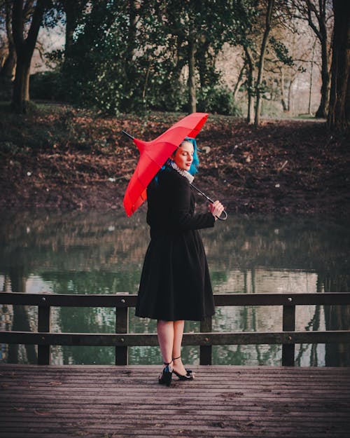 Frau Trägt Schwarzes Langärmeliges Kleid Mit Rotem Regenschirm