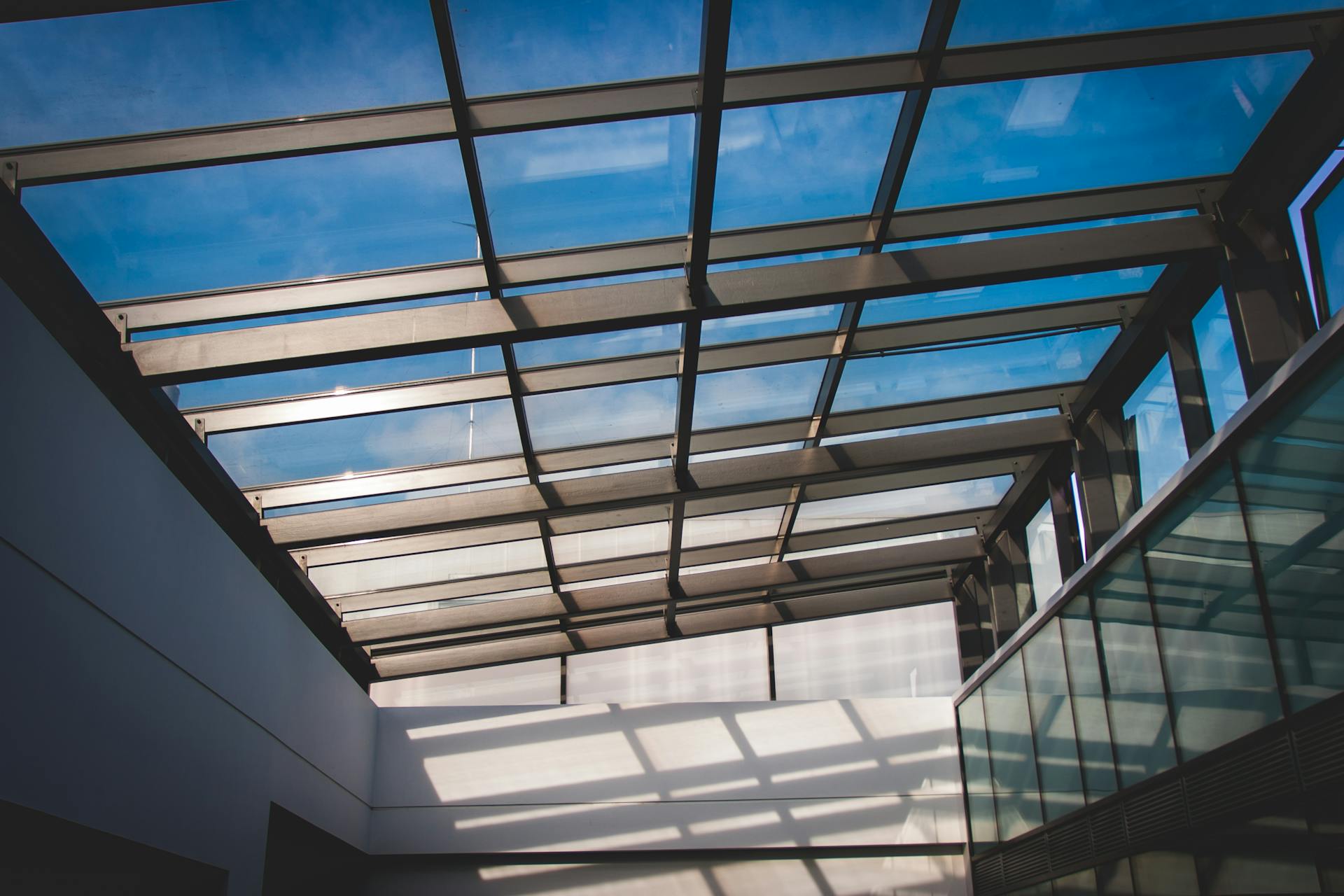 Contemporary architectural design showcasing a glass roof with clear sky view.