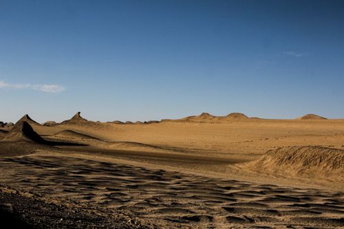 Free Expansive desert scene featuring sandy dunes and a bright blue sky, perfect for nature enthusiasts. Stock Photo