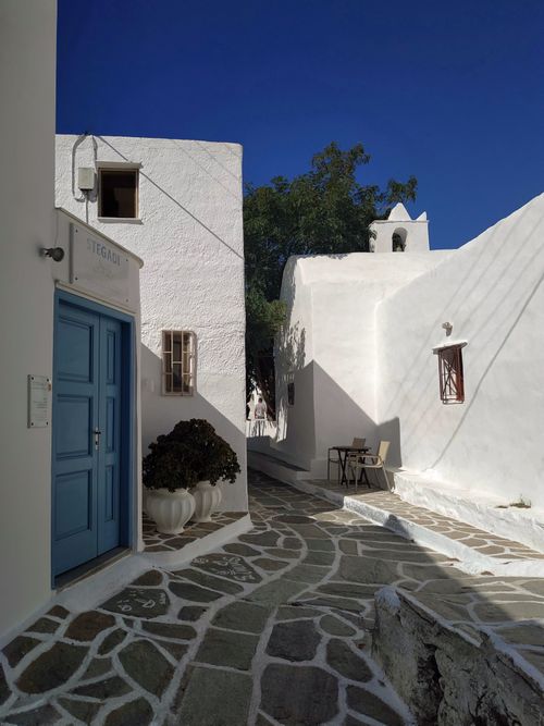 Free Serene cobblestone path between whitewashed buildings under clear sky. Stock Photo