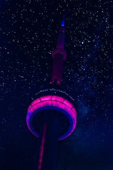 在加拿大多伦多，加拿大国家电视塔低视角的灯光充满活力，照亮了繁星点点的夜空