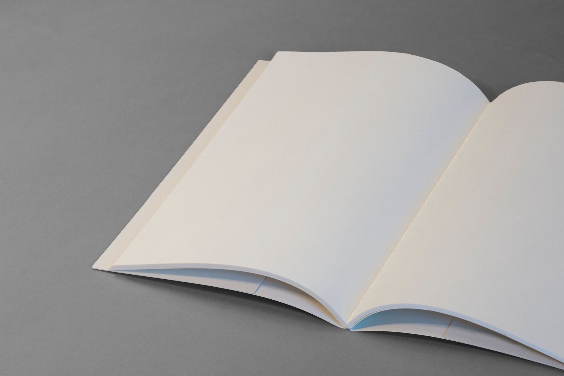 Open blank notebook on a gray background ideal for design mockups and presentations.