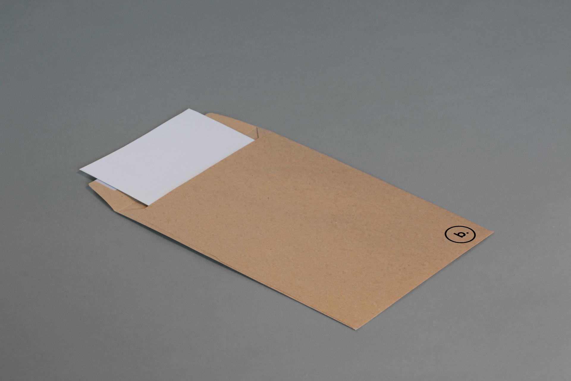 A simple brown envelope with a white paper insert on a neutral gray background.