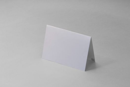 Minimalist blank white folded card mockup with ample copy space on a neutral background.