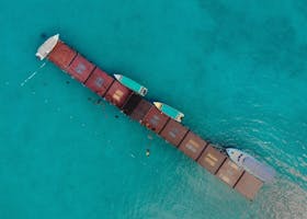 Aerial shot of a pier with boats in clear turquoise water, Kuala Terengganu, Malaysia.