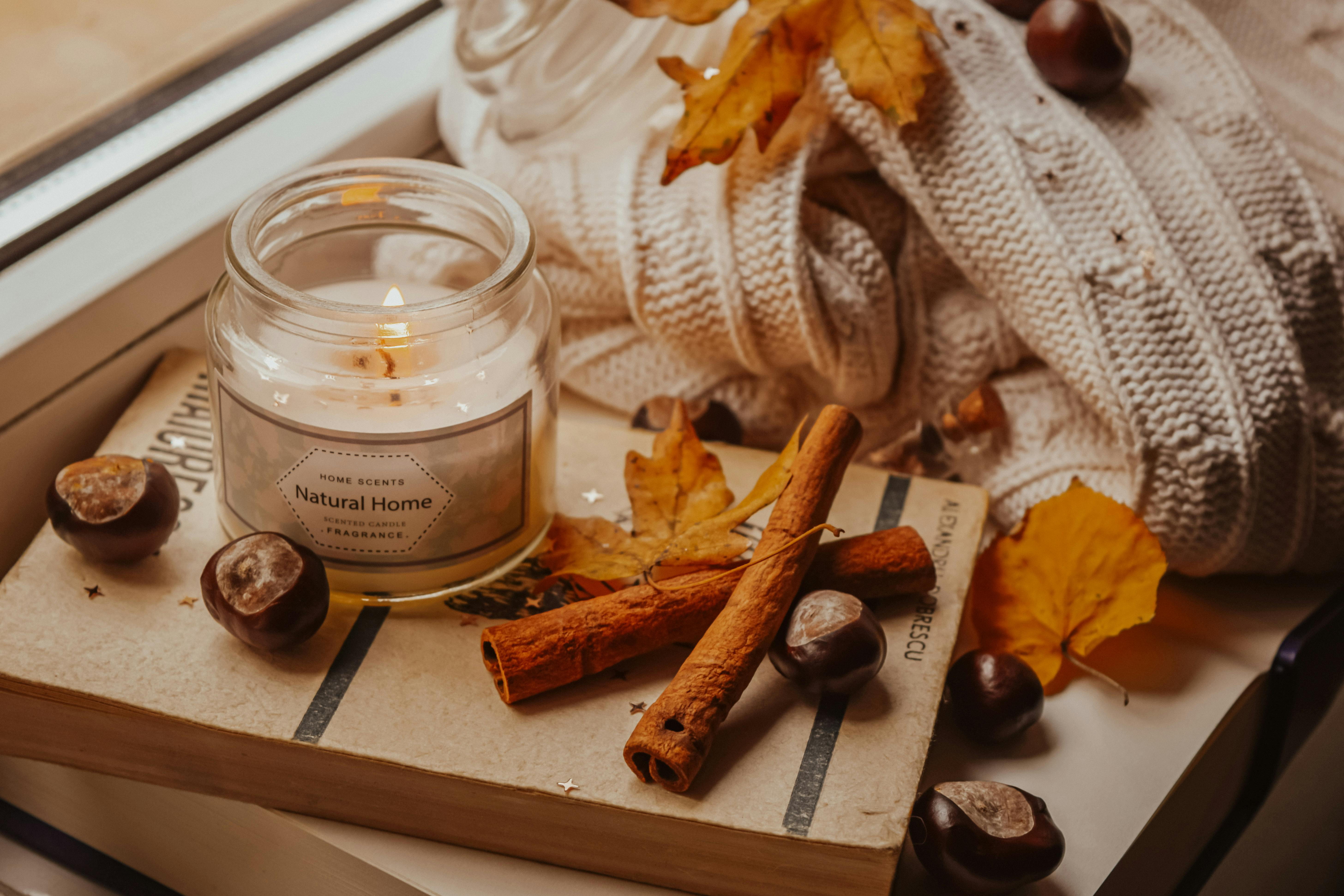 Candle in the Clear Glass Bottle Beside the Cinnamon Sticks and Knitted ...