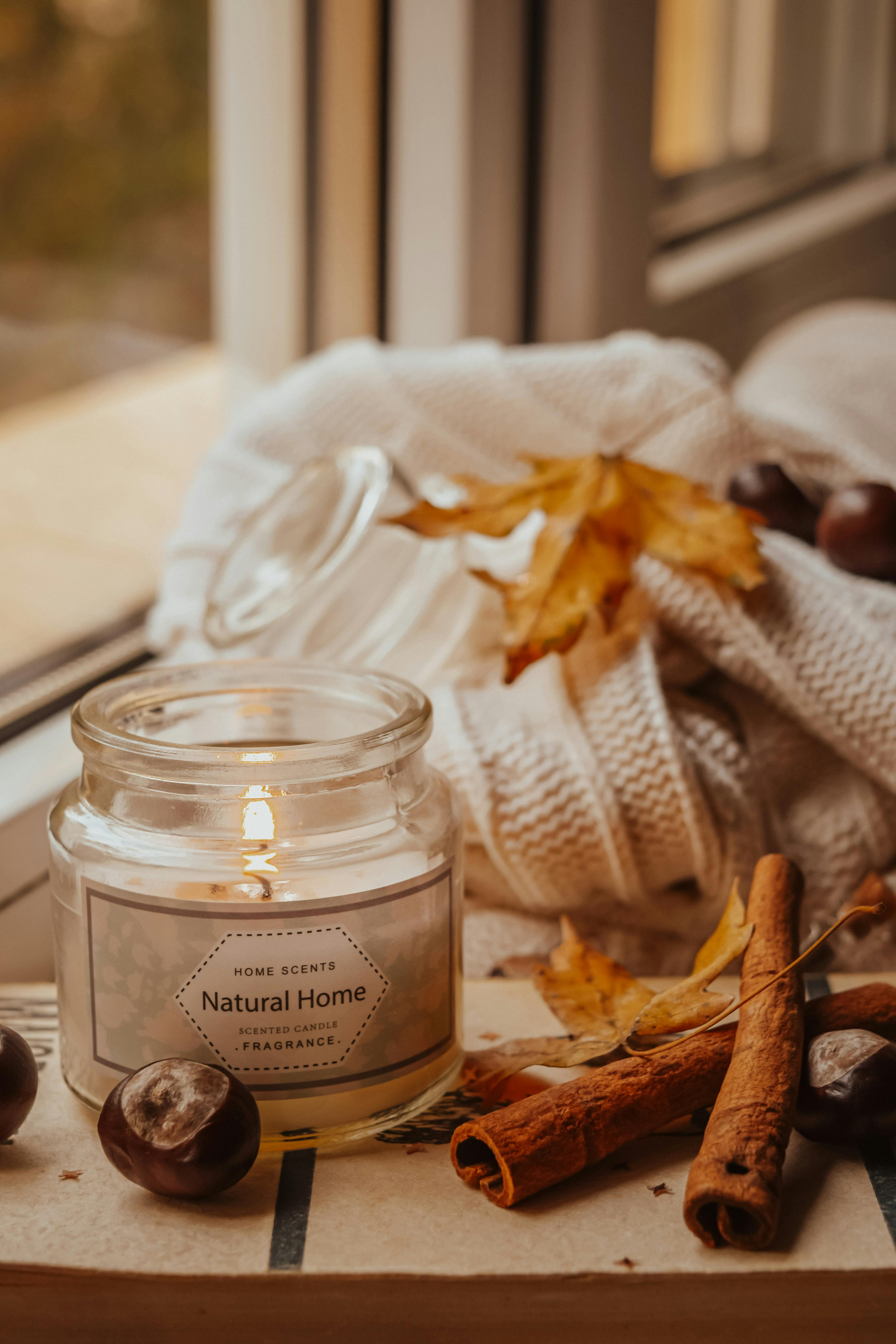 Candle in the Clear Glass Bottle Beside the Cinnamon Sticks and Knitted ...