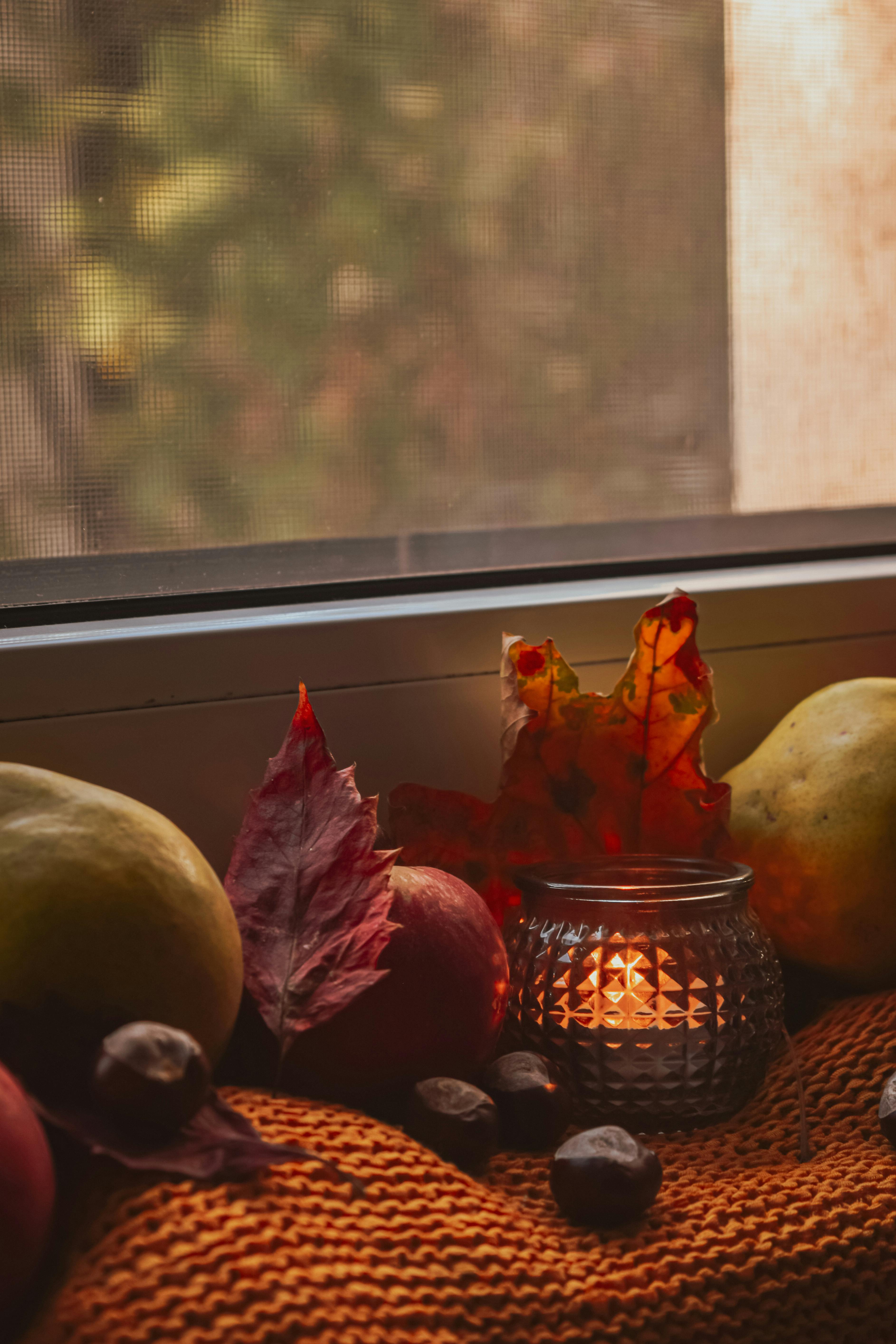 Dried Fruits and Lighted Candle on Window Sill · Free Stock Photo