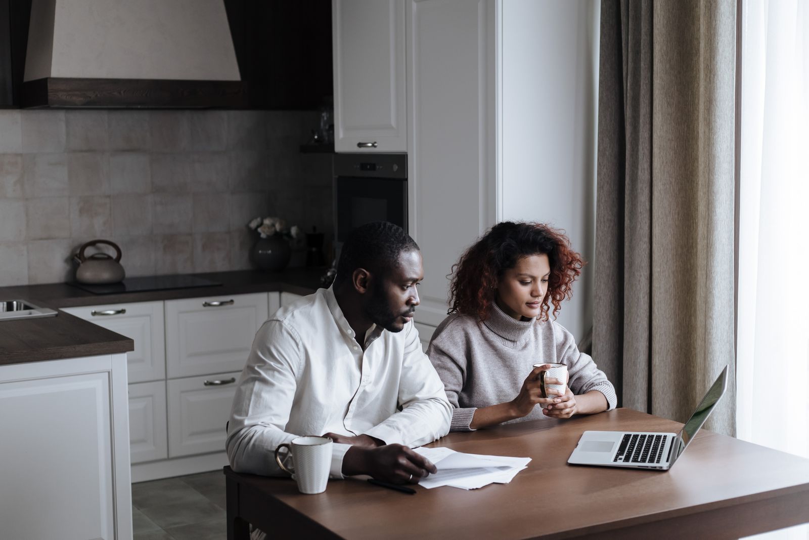 Two people looking at a laptop together at home