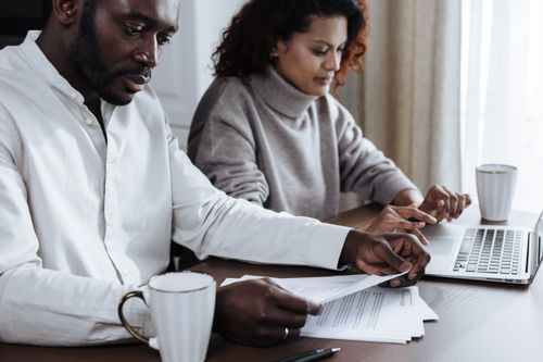 Free A diverse couple working together on a laptop at home, focused on collaboration and productivity. Stock Photo