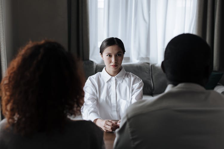 Rear View Of Couple Talking About Adoption With Social Worker