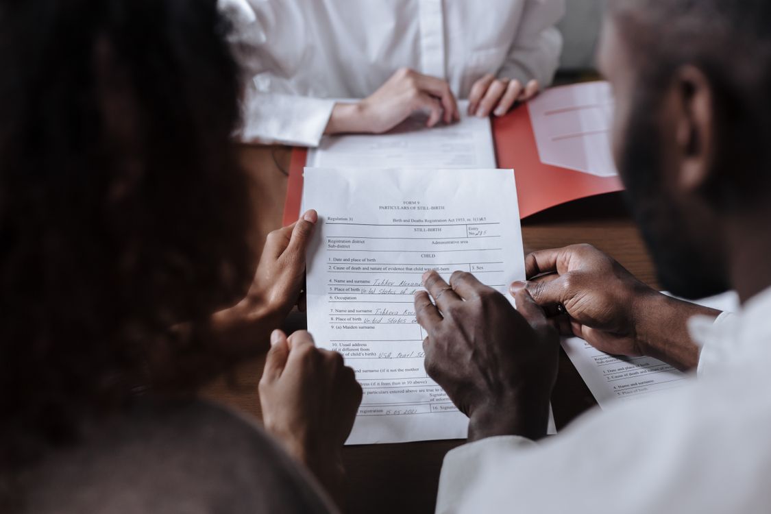 Couple signant des documents de financement avec une conseillère