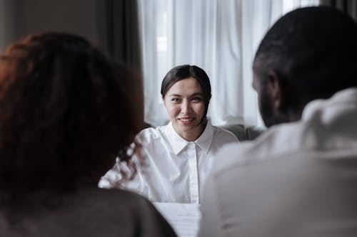 Free Social Worker Smiling at Couple Sitting Opposite Her Stock Photo