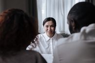 Social Worker Smiling at Couple Sitting Opposite Her