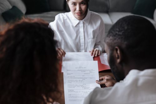 Free Three people reviewing documents in an office setting, focusing on adoption paperwork. Stock Photo