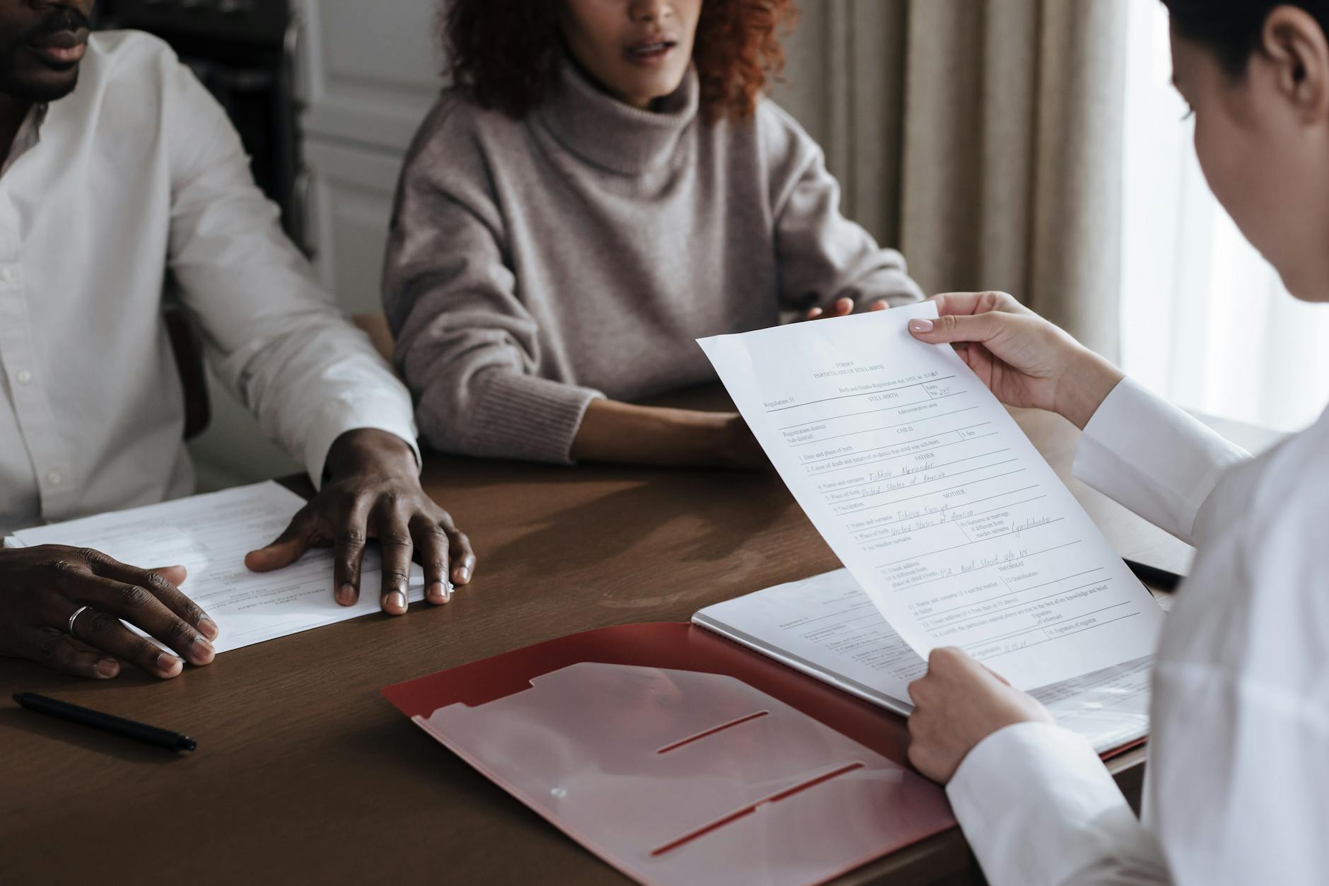 A diverse group of individuals discussing documents in a professional office environment.