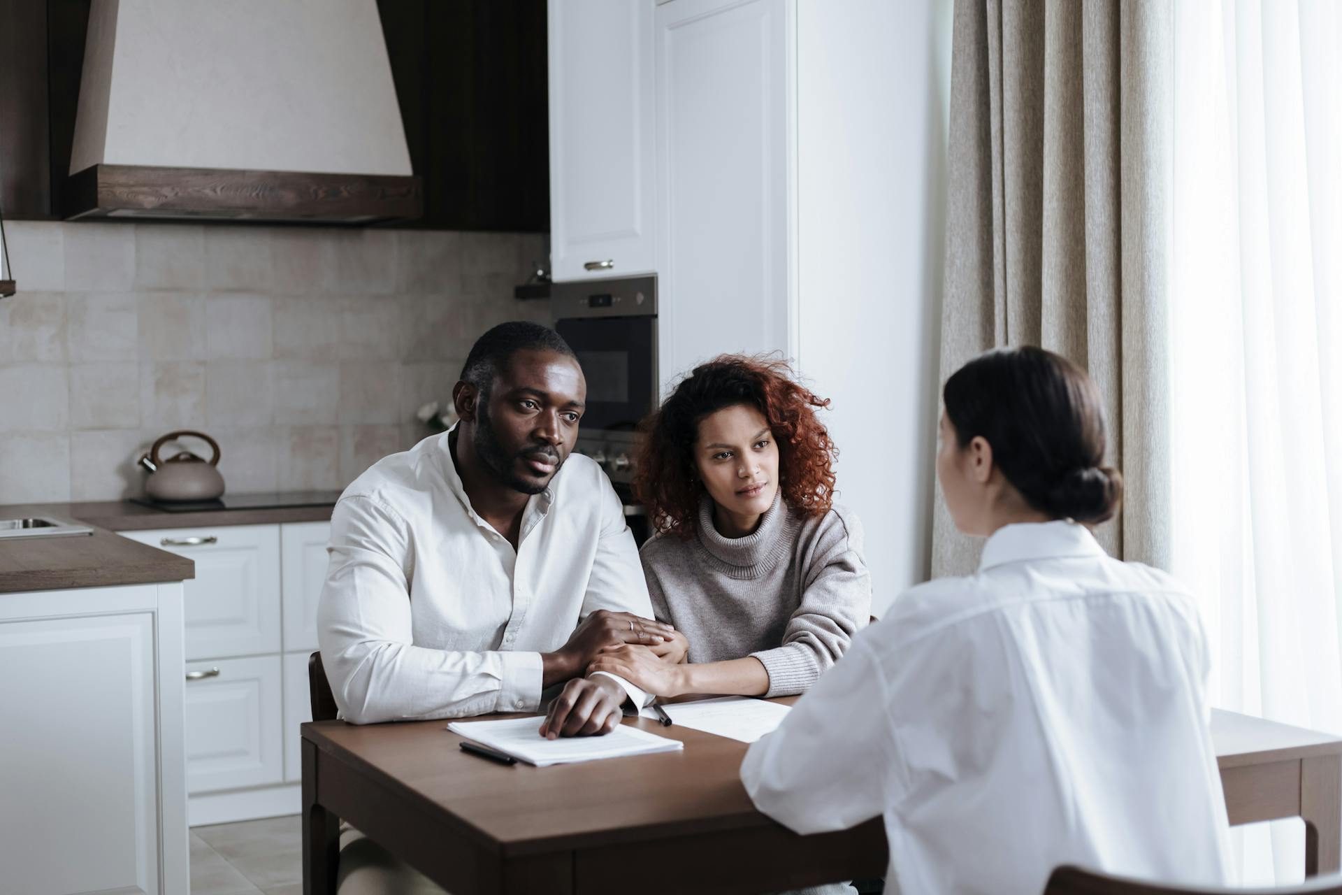 Couple Talking with Social Worker in Kitchen