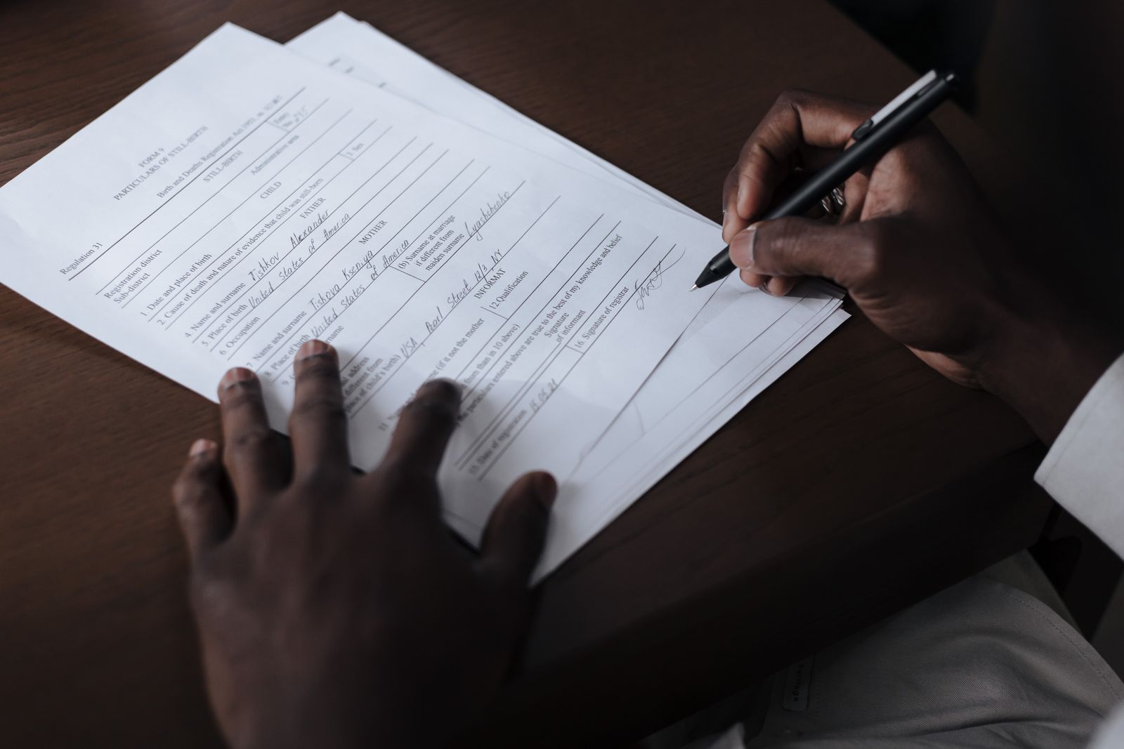 Des mains signent un document officiel