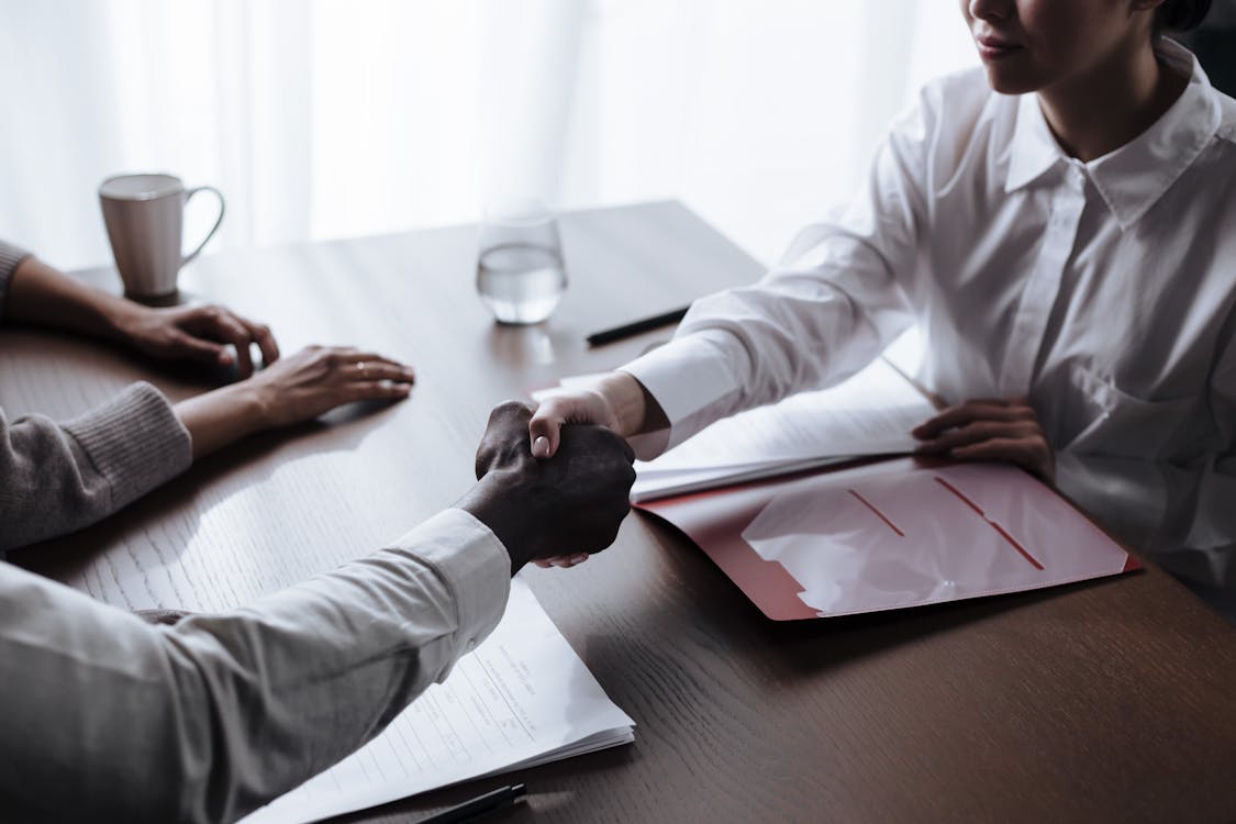 Free Unrecognizable Man Shaking Hands with Female Social Worker Stock Photo