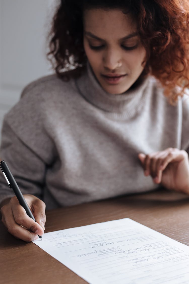 Young Woman Signing Adoption Document