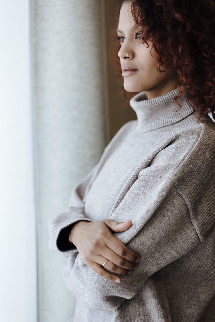 Attractive Woman With Standing By Window And Looking Far Distance