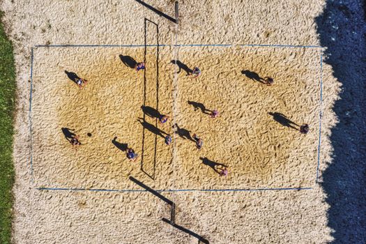 Top view of people playing a fun beach volleyball game outdoors in Plainview.