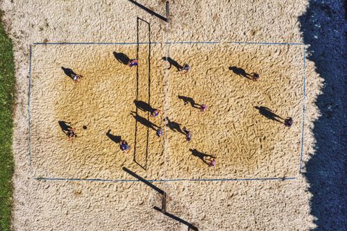 Free Top view of people playing a fun beach volleyball game outdoors in Plainview. Stock Photo