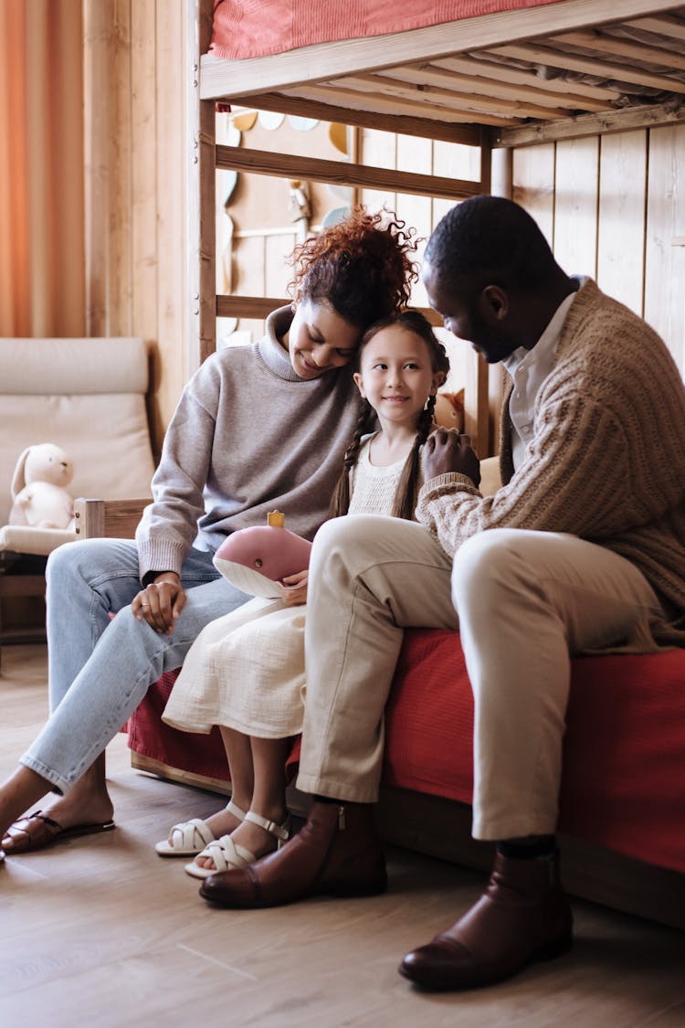 A Family Sitting On A Bed