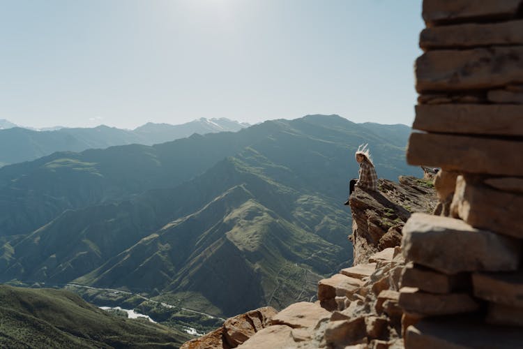 Person Sitting On The Edge Of The Cliff 