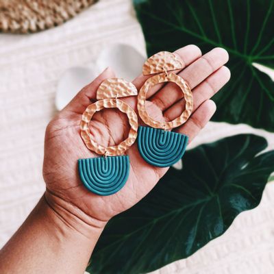 Handmade hammered-copper earrings on a palm — photo by Jocelyn Riley on Pexels
