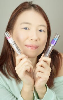 Portrait of a woman holding colorful dual-ended lipsticks, showcasing beauty and style.