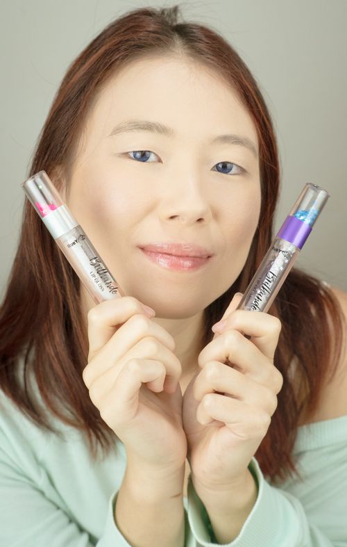 Free Portrait of a woman holding colorful dual-ended lipsticks, showcasing beauty and style. Stock Photo