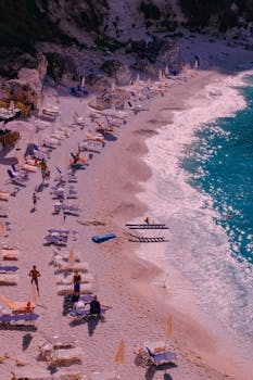 A captivating aerial shot of a peaceful summer beach with chairs and umbrellas, perfect for relaxation.