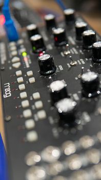 Vertical shot of a Moog audio mixing panel with knobs and connectors, taken in a studio setting.