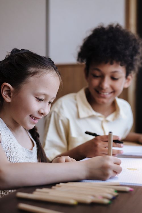 Free Two children happily drawing together indoors, showcasing creativity and childhood joy. Stock Photo