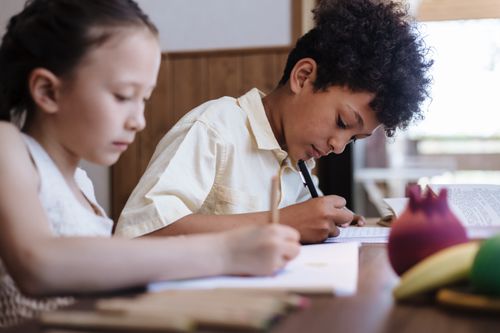 Free Two children focusing on their homework indoors, representing learning and sibling interaction. Stock Photo